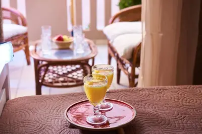 a glass of orange juice on a plate on a table at Natasha's Luxury apartment by the sea in Galatás
