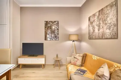 a living room with a couch and a tv at Natasha's Luxury apartment by the sea in Galatás