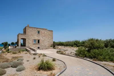 a stone house in the desert with a pathway at Beachfront villa Turquoise with private pool, BBQ and ping pong table in Chania Town