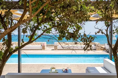 a view of a swimming pool with the ocean in the background at Beachfront villa Turquoise with private pool, BBQ and ping pong table in Chania Town