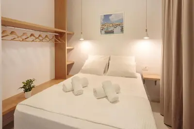 a bedroom with a bed with white sheets and pillows at Terpsis Estate in Chania Town