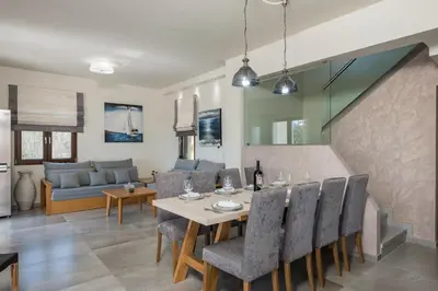 a dining room and living room with a table and chairs at Villa Nina with Private Pool in Kolymvari