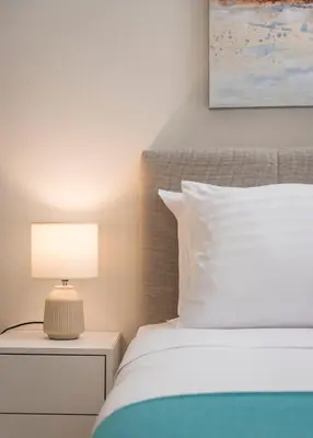 a bedroom with a bed and a lamp on a night stand at CALMERA Luxury Living in Chania Town