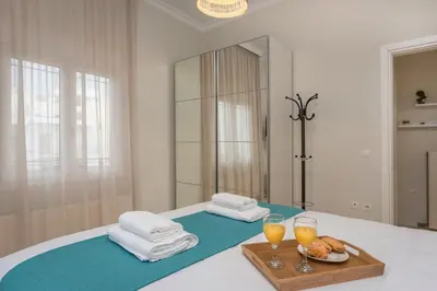 a room with a bed with two glasses of orange juice at CALMERA Luxury Living in Chania Town