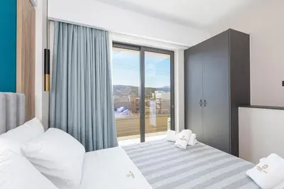 a bedroom with a bed and a large window at Sapphire Blue Suites in Kissamos