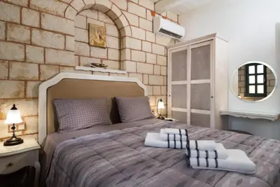 a bedroom with a large bed with a brick wall at Estia Luxury Living in Chania Town