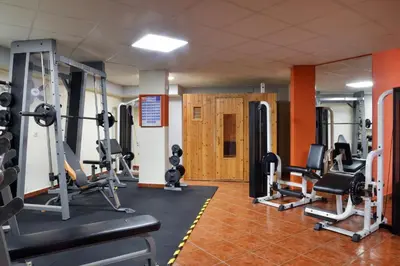 a gym with several treadmills and weights at Sissy Village All Suite Hotel in Kounoupidhianá