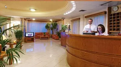 a man and woman standing at a bar in a lobby at Sissy Village All Suite Hotel in Kounoupidhianá