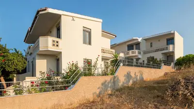 a white house on a hill with stairs at Villa Krini in Kalathas