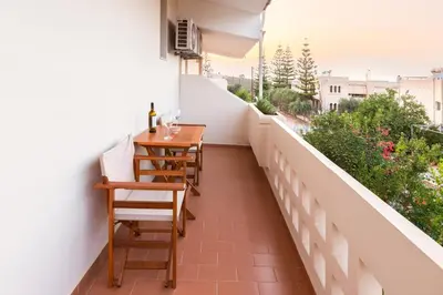a balcony with two chairs and a table on it at Villa Krini in Kalathas