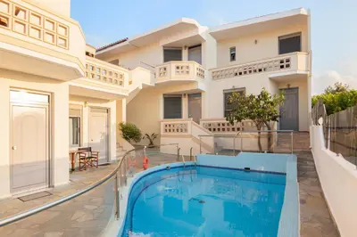 a villa with a swimming pool in front of a house at Villa Krini in Kalathas