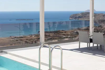 a balcony with a table and chairs next to a pool at Falasarna village in Falasarna