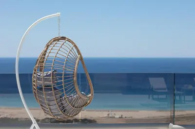 a metal object hanging from a window with a beach at Falasarna village in Falasarna