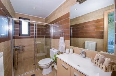 a bathroom with a toilet and a sink and a shower at Villa Elisabeth View in Plataniás