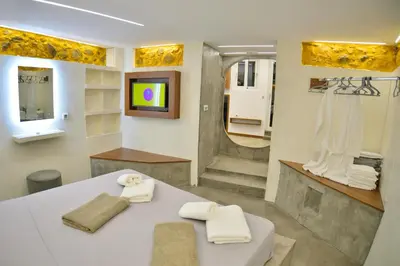 a bathroom with a white table and a television at CAVE Luxury House in Kissamos