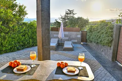 a table with two plates of food and two glasses of wine at CAVE Luxury House in Kissamos