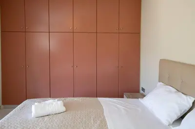 a bedroom with a bed with brown cabinets at Blue and green in Chania Town