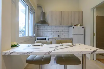 a kitchen with a large marble counter top with chairs at Just For Two in Chania Town