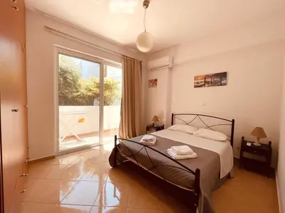 a bedroom with a bed and a large window at Alcyone Apartment in Kissamos