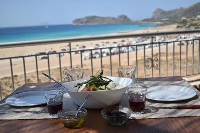 a bowl of salad on a table with a view of the beach at Panorama Hotel in Falasarna
