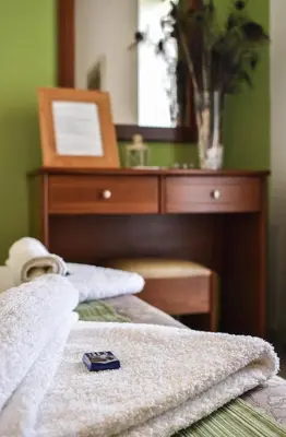 a close up of a bed with a dresser with a mirror at Panorama Hotel in Falasarna