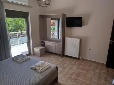 a bedroom with a bed and a tv and a window at Giannis Villa in Skinés