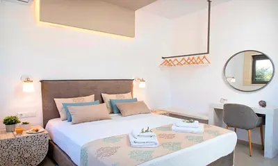 a bedroom with a bed and a desk and a mirror at Orientem Villa Heated Pool in Georgioupoli