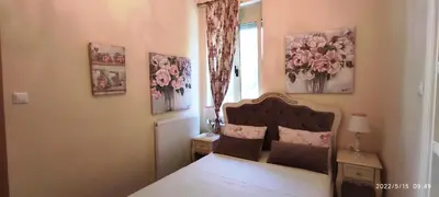 a bedroom with a bed and a window with pink flowers at BLUE EYES VILLA in Chania Town