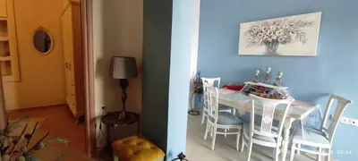 a dining room table with white chairs and a blue wall at BLUE EYES VILLA in Chania Town