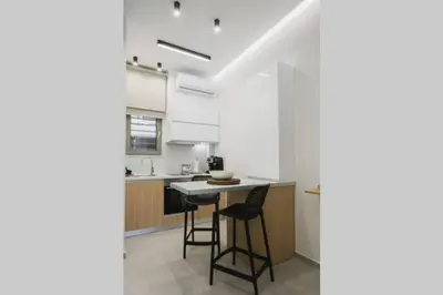 a kitchen with a table and chairs in a room at Peris 5 with Yard steps to Bus St & Old Town in Chania Town