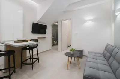 a living room with a couch and a table at Peris 5 with Yard steps to Bus St & Old Town in Chania Town