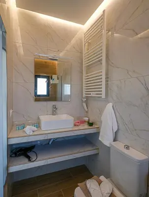 a bathroom with a sink and a toilet and a mirror at Villa Belle Helene Kalamaki Chania in Kalamaki Chanion
