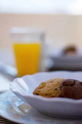 a plate with cookies on a table with a glass of orange juice at Nikis Apartment 2 in Chania Town