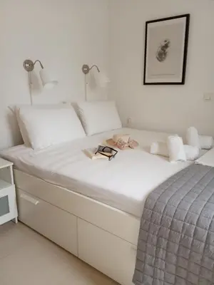 a white bed with a book and glasses on it at Nikis Apartment 3 in Chania Town