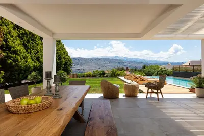 a patio with a table and chairs and a pool at Artemisia Residence in Chania Town