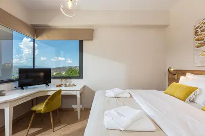 a bedroom with a bed and a desk with a television at Artemisia Residence in Chania Town