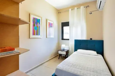 a small bedroom with a bed and a window at Adorno Luxury Villa in Chorafakia