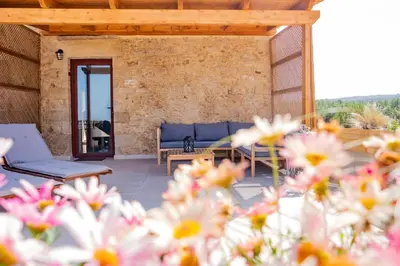 a patio with a couch and flowers in the foreground at Villa Styliani in Kissamos