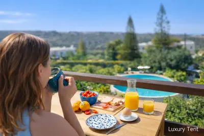 a young woman sitting at a table with a tray of food at dream tiny house & luxury tent, 6 km from center Chania in Chania Town