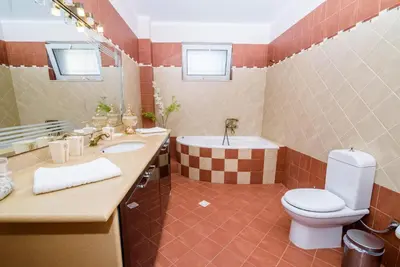 a bathroom with a toilet and a sink and a tub at Andronikis House in Pithárion