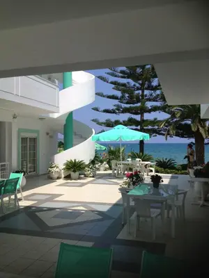 a patio with a table and an umbrella and the ocean at Kristall Suites in Stalos