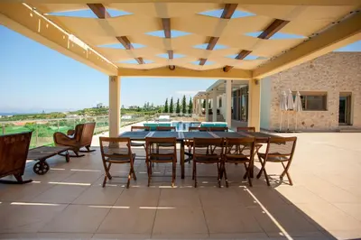 a dining room with a table and chairs on a patio at Luxury 6-Bedroom Villa With Private Pool- Villa Prigipessa in Chania Town