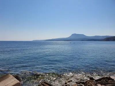a large body of water with mountains in the background at Aphrodite Apartments in Kalyves