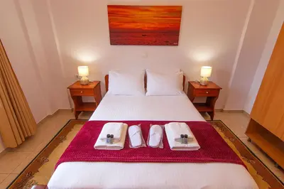 a bedroom with a bed with two towels and two lamps at Liviko Beach Apartments - only adults in Frangokastello