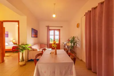 a room with a table and a living room with a couch at Liviko Beach Apartments - only adults in Frangokastello