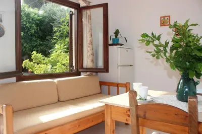 a living room with a couch and a window at Maria's Apartments in Kalyves