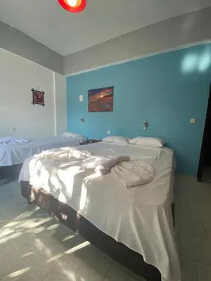 a bedroom with two beds and a blue wall at Orthi Ammos in Frangokastello