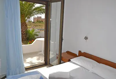 a bedroom with a bed and a window with a view at Orthi Ammos in Frangokastello