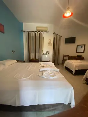 a hotel room with two beds with white sheets at Orthi Ammos in Frangokastello