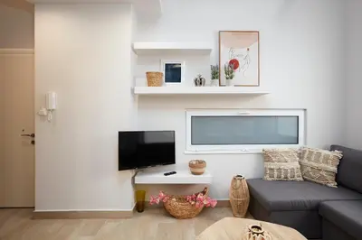 a living room with a couch and a flat screen tv at Chrissula apt Homeleader in Chania Town